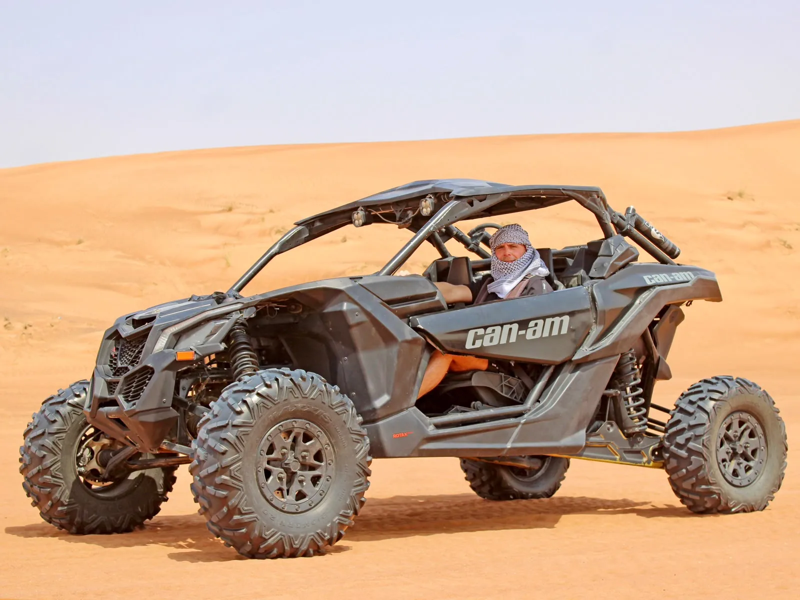 Guests riding a Can-Am Maverick X3 four seater dune buggy in the Dubai desert