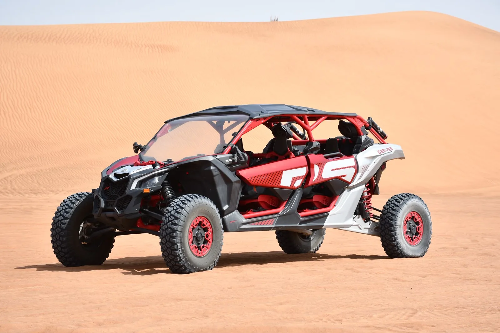 Red Can-Am Maverick X3 X RS turbo four seater dune buggy on the Dubai red dunes