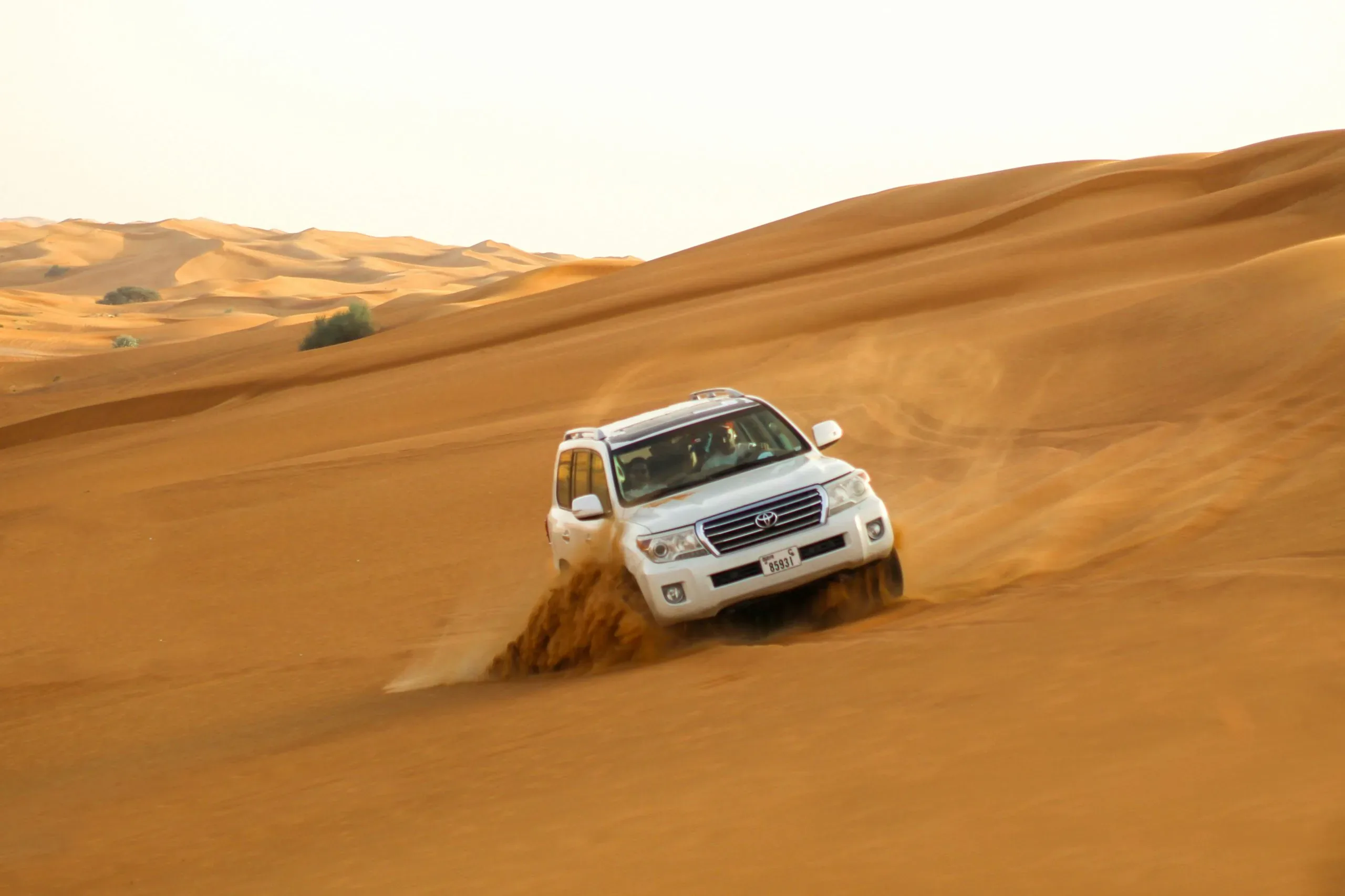 Land Cruiser dune bashing through the red dunes on a Dubai desert safari