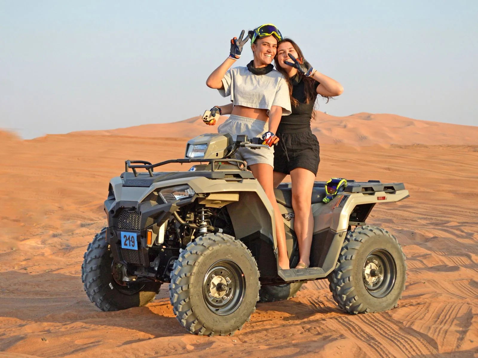 Two guests on a double seat quad bike at sunset in the Dubai desert