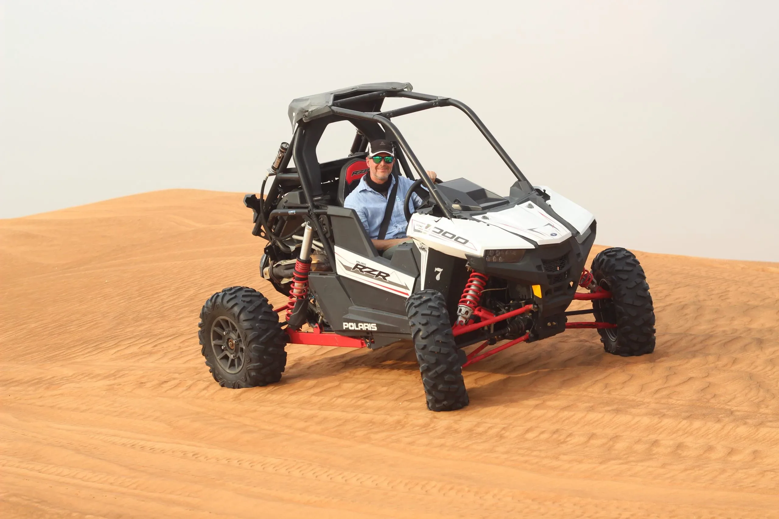 Polaris dune buggy driving across the Lahbab red dunes in Dubai