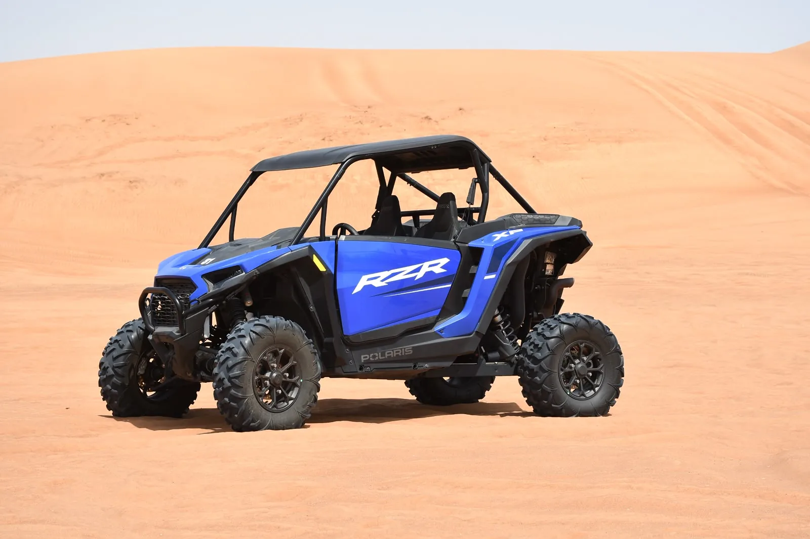 Blue Polaris RZR Pro dune buggy on a red dune at the Lahbab desert in Dubai