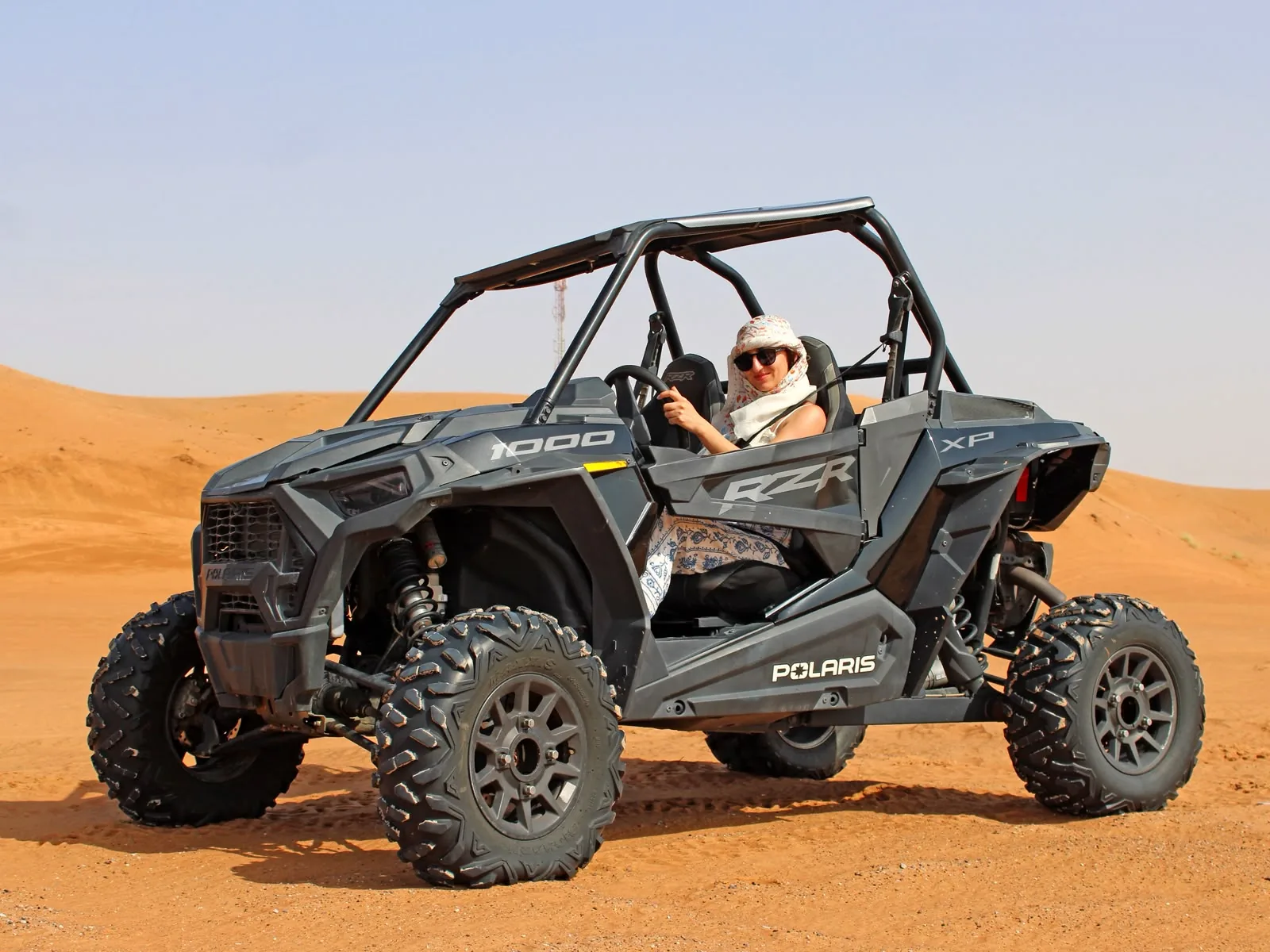 Guests driving a Polaris RZR XP 1000 turbo two seater through the Dubai desert