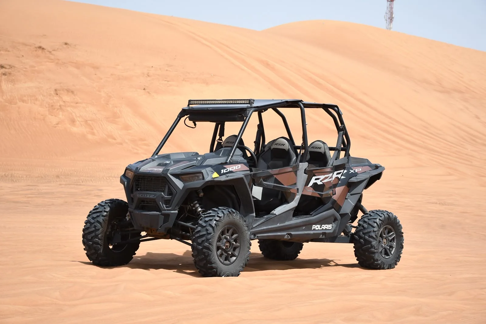 Black Polaris RZR turbo four seater dune buggy on the Dubai red dunes