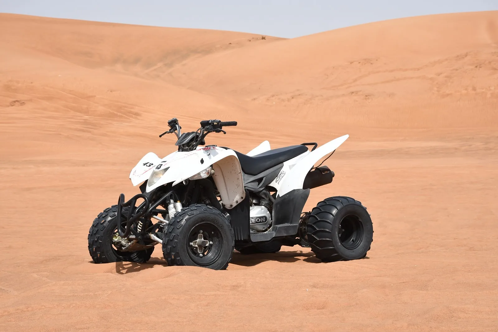 White single seat quad bike ready to ride on the Lahbab red dunes in Dubai