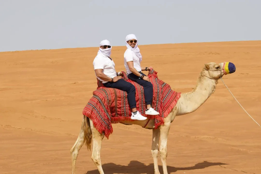 Guests on a camel ride during a Dubai desert safari