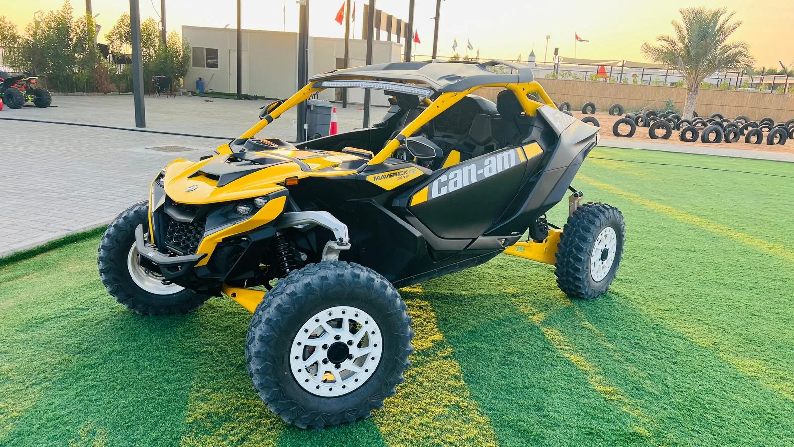 Yellow Can-Am Maverick R dune buggy at the Al Awir base yard at sunrise