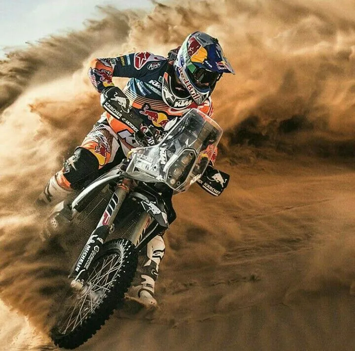 Motocross rider powering a dirt bike through soft sand in the Dubai desert