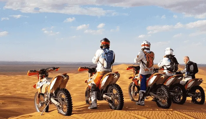 Group of dirt bike riders lined up before a guided Dubai desert tour