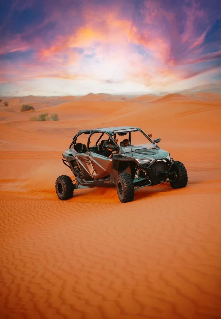 Dune buggy on a red dune at sunset during a Lahbab desert ride in Dubai