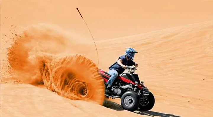 Child riding a small kids quad bike in the fenced area at the Dubai base