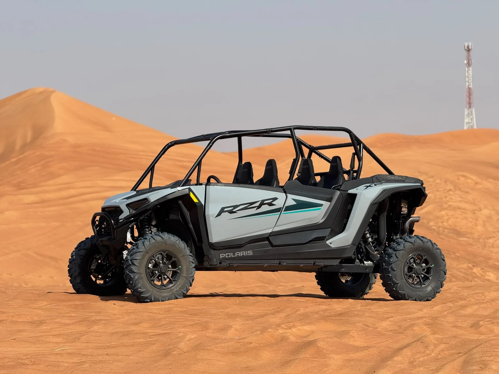 Side profile of a Polaris RZR four seater dune buggy in the Dubai desert