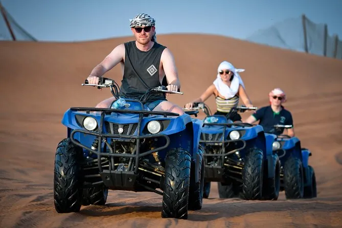 Three riders on quad bikes during an open desert tour in Dubai