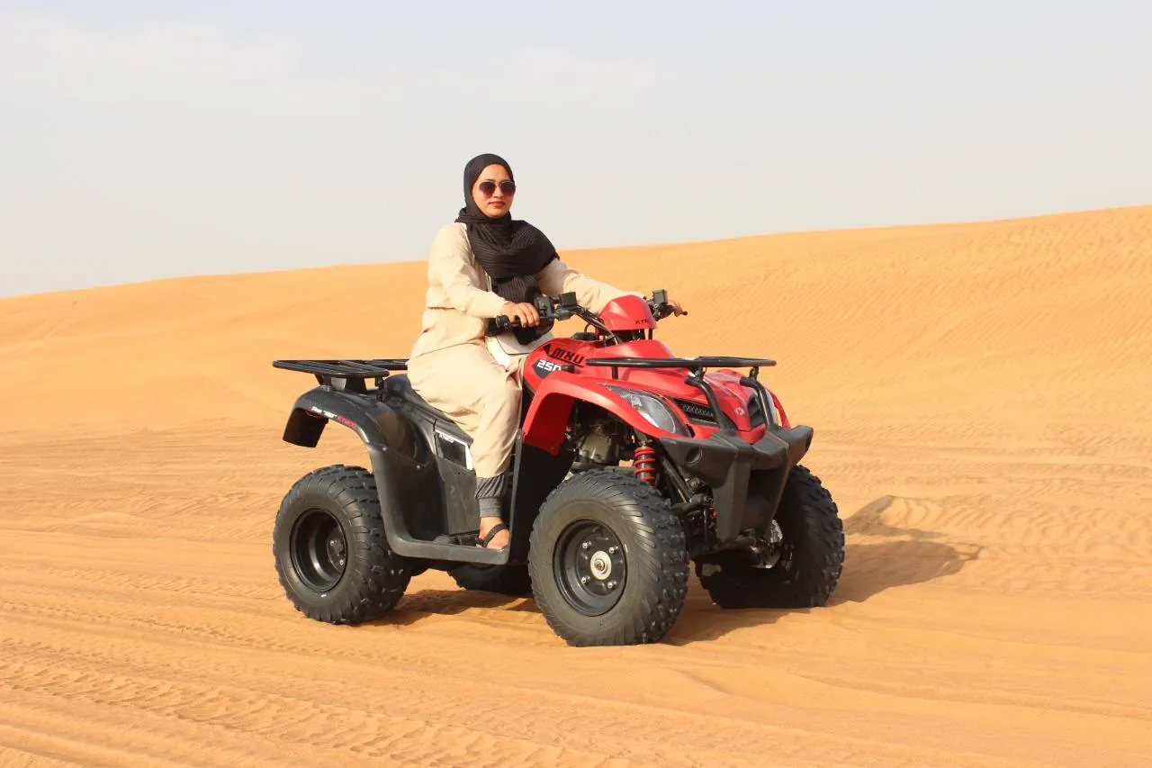 Rider on a single seat quad bike crossing Dubai desert sand